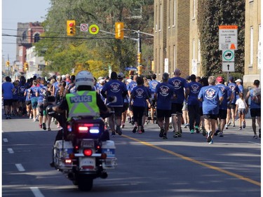 Runners participating in the National Peace Officers Memorial Run get a motorcycle escort lead runners up Elgin St. in downtown Ottawa, Saturday, September 27, 2014. Hundreds of police officers ran 460km from Toronto to Ottawa, past Ottawa Police headquarters then up Elgin to Parliament Hill.