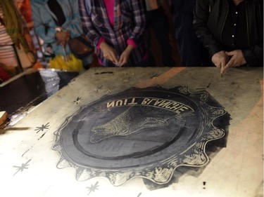 Stencils are cut at the Steamrolling print making project on George St. during Nuit Blanche in Ottawa, on Saturday, September 20, 2014.