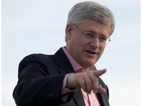Canadian Prime Minister Stephen Harper gestures toward cameras as he prepares to leave Whitehorse on Friday August 22, 2014.
