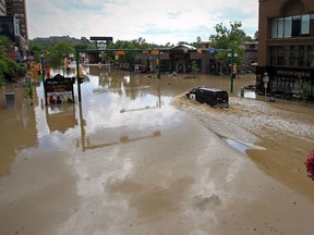 A police van drives through the flooded intersection in Calgary, Alberta on June 22, 2013.