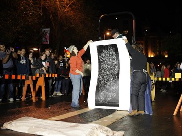 The art is revealed at the Steamrolling print making project on George St. during Nuit Blanche in Ottawa, on Saturday, September 20, 2014.