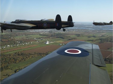 The Canadian Warplane Museum's Avro Lancaster bomber is escorted back to Vintage Wings of Canada at the Gatineau Airport, Sept. 27, 2014. The plane was escorted by Michael Potter, flying a P-51 Mustang, and Rob Erdos, piloting a P-40 Kittyhawk.