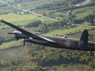 The Canadian Warplane Museum's Avro Lancaster bomber is escorted back to Vintage Wings of Canada at the Gatineau Airport, Sept. 27, 2014. The plane was escorted by Michael Potter, flying a P-51 Mustang, and Rob Erdos, piloting a P-40 Kittyhawk.