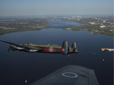 The Canadian Warplane Museum's Avro Lancaster bomber is escorted back to Vintage Wings of Canada at the Gatineau Airport, Sept. 27, 2014. The plane was escorted by Michael Potter, flying a P-51 Mustang, and Rob Erdos, piloting a P-40 Kittyhawk.