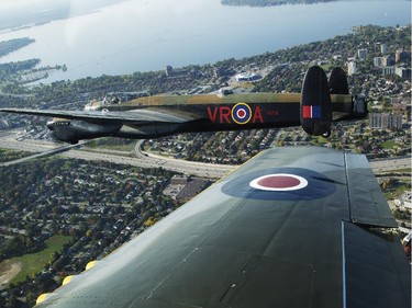 The Canadian Warplane Museum's Avro Lancaster bomber is escorted back to Vintage Wings of Canada at the Gatineau Airport, Sept. 27, 2014. The plane was escorted by Michael Potter, flying a P-51 Mustang, and Rob Erdos, piloting a P-40 Kittyhawk.