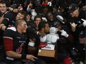 The Carleton Ravens celebrate with the Panda after a thrilling victory over the University of Ottawa Gee-Gees on Saturday, Sept. 20, 2014.