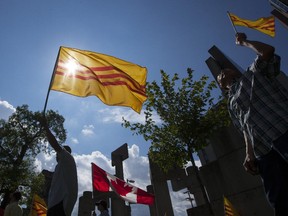 The Freedom Flag of Vietnam is silhouetted agaionst the sun during a demonstration at the Human Rights Monument in Ottawa over the City of Ottawa's decision to fly the communist flag of Vietnam to mark the country's day of independence.