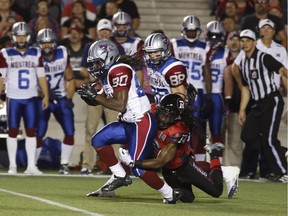 The Montreal Alouettes' James Rodgers is tackled by the Ottawa Redblacks' Abdul Kanneh in CFL action at TD Place on Sept. 26, 2014.