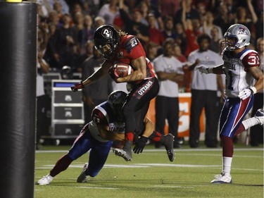 The Ottawa Redblacks' Jonathan Williams evades a tackle for a touchdown in CFL action against the Montreal Alouettes at TD Place on Sept. 26, 2014.