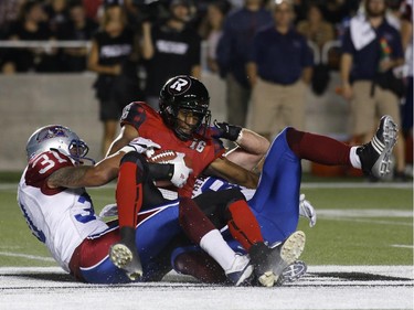 The Ottawa Redblacks Marcus Henry is tackled by the Montreal Alouettes in CFL action at TD Place on Sept. 26, 2014.