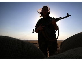 TOPSHOTS An Iranian Kurdish female member of the Freedom Party of Kurdistan (PAK) keeps a position in Dibis, some 50 kms northwest of Kirkuk, on September 15, 2014. The world's top diplomats pledged today to support Iraq in its fight against Islamic State militants by "any means necessary", including "appropriate military assistance", as leaders stressed the urgency of the crisis.