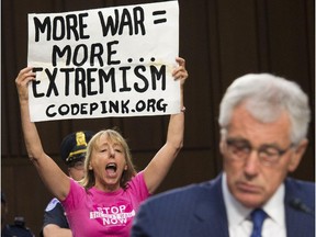 A protestor with the organization CodePink demonstrates as U.S. Secretary of Defense Chuck Hagel testifies on U.S. policy towards Iraq and Syria and the threat posed by the Islamic State during a Senate Armed Services Committee hearing on Capitol Hill in Washington, D.C., Sept. 16, 2014.