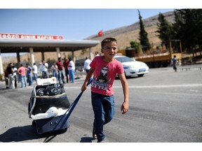 A child pulls a suitcase as Syrian refugees arrive in Turkey at the Cilvegozu crossing gate of Reyhanli, in Hatay, on August 31, 2013. Efforts to close the border to jihadists will also hamper humanitarian efforts in the area.
