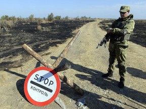 A Ukrainian serviceman stands guard at a Ukrainian National Guard position on the border checkpoint near Novoazovsk, Donetsk region after a multiple launch rocket systems and the cannon were allegedly fired from the Russian Federation territory on Aug. 23, 2014.