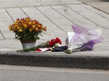 A memorial of flowers and a Canadian flag and a cap at the Cenotaph. Police remain on the scene Oct 23 at the Cenotaph where a soldier was shot dead Oct 22. The gunman was later killed when he stalked the halls of Parliament Hill.