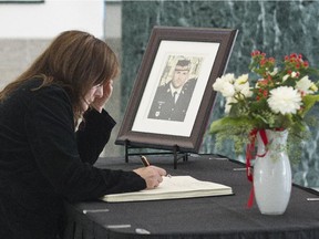 A woman signs the Book of Remembrance Thursday at Ottawa City Hall in honour of Cpl Nathan Cirillo who was killed while guarding the War Memorial on Wednesday.