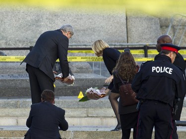 Prime Minister Stephen Harper and Laureen Harper paid their respects and laid flowers amid crime scene markers Oct 23 at the Cenotaph where a soldier was shot dead Oct 22. The gunman was later killed when he stalked the halls of Parliament Hill.