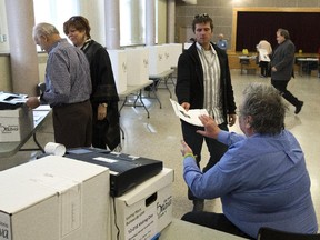 A man watches as his ballot is recorded at Richelieu-Vanier Community Centre Oct 27 for the City of Ottawa municipal election.