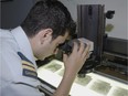 This August 2007 file photo shows Captain Mark Chlistovski, an Aeronautical Engineer employed as a Sensor Officer with Open Skies Canada. He is shown here examining aerial film that was shot over the territory of the Russian Federation. DND photo.