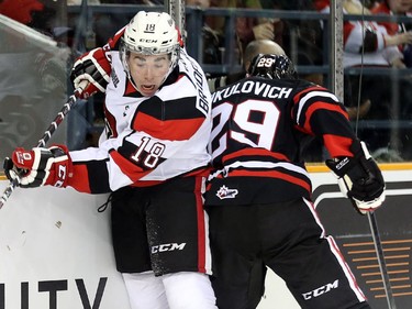 67 Erik Bradford is checked into the boards by Aleksander Mikulovich, right, in the first period as the Ottawa 67's take on the Niagara Ice Dogs in their home opener at the renovated TD Place arena.