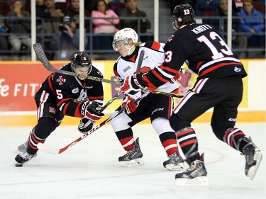 67's forward Artur Tyanulin splits the defence of Blake Siebenaler, left, and Graham Knott, right, in the first period as the Ottawa 67's take on the Niagara Ice Dogs in their home opener at the renovated TD Place arena.