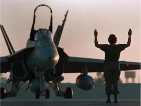 A Canadian CF-18 gets the go-ahead for takeoff at dusk . CP Photo