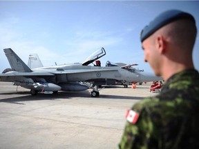 A Canadian soldier looks at a CF-18 at Camp Fortin in Trapani, Italy, on September 1, 2011.