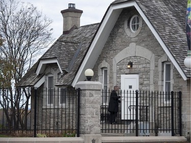 A heavily armed RCMP officer enters 24 Sussex Dr., the official residence of the Prime Minister, on Wednesday, Oct. 22, 2014. A soldier standing guard at the National War Memorial in Ottawa has been shot by an unknown gunman and people report hearing gunfire inside the halls of Parliament.