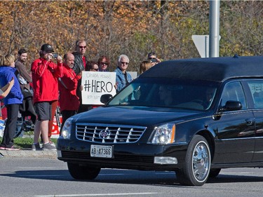 A large group of bystanders gathered to watch the funeral procession for Cpl Nathan Cirillo travel along West Hunt Club Rd at Knoxdale on his way home to Hamilton.