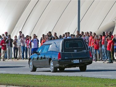 A large group of bystanders gathered to watch the funeral procession for Cpl Nathan Cirillo travel along West Hunt Club Rd at Knoxdale on his way home to Hamilton.