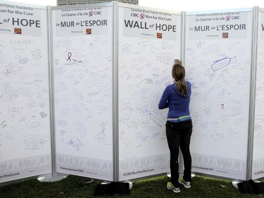 A participant writes on the Wall of Hope at the CIBC Run for the Cure in Ottawa on Sunday, October 5, 2014.