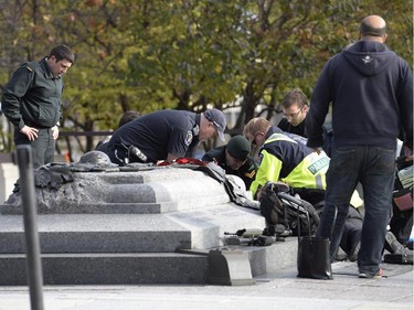 A soldier, police and paramedics tend to a soldier shot at the National Memorial near Parliament Hill in Ottawa on Wednesday Oct.22, 2014.