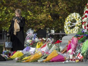 A woman leaves the Tomb of the Unknown Soldier after paying her respects at the National War Memorial, where Cpl. Nathan Cirillo, 24, was killed by a gunman, in Ottawa on Friday, Oct. 24, 2014.