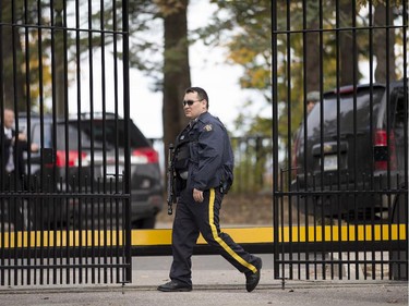 An armed RCMP officer stands guard at 24 Sussex Dr., the official residence of the Prime Minister, on Wednesday, Oct. 22, 2014. A soldier standing guard at the National War Memorial in Ottawa has been shot by an unknown gunman and people report hearing gunfire inside the halls of Parliament.