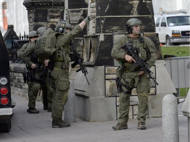 An RCMP intervention team secures an entrance to Parliament Hill in Ottawa on Wednesday Oct.22, 2014. A Canadian soldier standing guard at the National War Memorial in Ottawa has been shot by an unknown gunman and there are reports of gunfire inside the halls of Parliament.