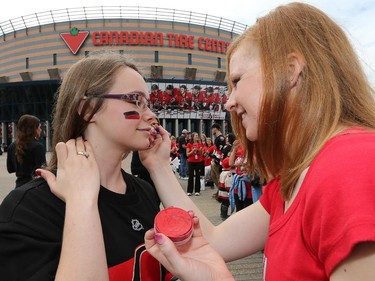 Ashley Cardinal, left, is face painted by Natasha Kippers.