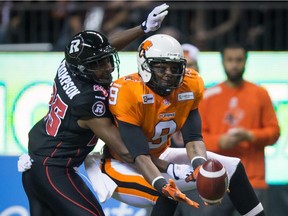 B.C. Lions' Ernest Jackson, right, makes a reception as Ottawa Redblacks' Brandyn Thompson defends during the first half of a CFL football game in Vancouver, B.C., on Saturday, October 11, 2014.