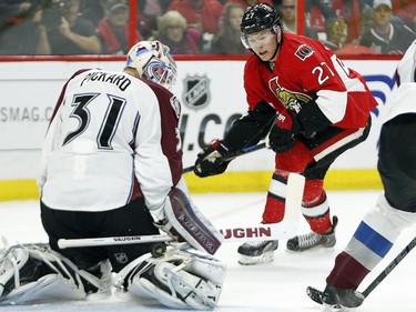 Calvin Pickard, left, manages to stop the Curtis Lazar shot in the first period.
