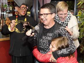 Catherine McKenney receives a hug from her daughter Kenney Vandelinde and her wife Catharine Vandelinde (behind) at Shanghai restaurant as she wins Ottawa City Council position for Somerset ward on Monday, Oct. 27, 2014. (James Park / Ottawa Citizen)