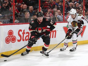 Curtis Lazar #27 of the Ottawa Senators skates with the puck against Trevor van Riemsdyk #57 of the Chicago Blackhawks.