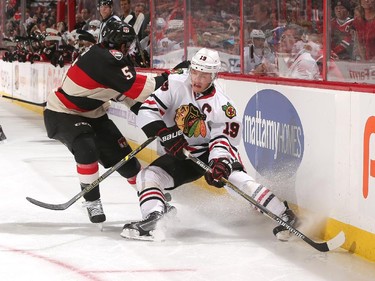 Cody Ceci #5 of the Ottawa Senators strips the puck from Jonathan Toews #19 of the Chicago Blackhawks along the boards.