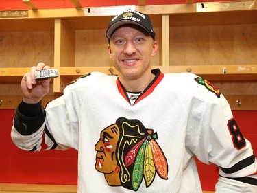 Marian Hossa #81 of the Chicago Blackhawks poses with the puck with which he scored his one thousandth point.