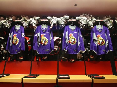 Purple Ottawa Senators warmup jerseys hang in the locker room on Hockey Fights Cancer night before the game.