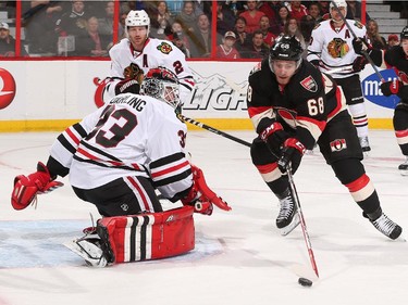 Mike Hoffman #68 of the Ottawa Senators dekes Scott Darling #33 of the Chicago Blackhawks on a scoring chance.