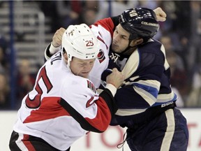 Ottawa Senators' Chris Neil, left, and Columbus Blue Jackets' Jared Boll fight during the first period.
