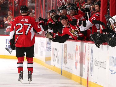 Chris Neil #25 of the Ottawa Senators celebrates a first period goal against the Colorado Avalanche with teammate Curtis Lazar #27.