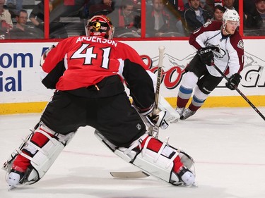 Craig Anderson #41 of the Ottawa Senators guards his net as Jamie McGinn #11 of the Colorado Avalanche considers passing or shooting the puck.