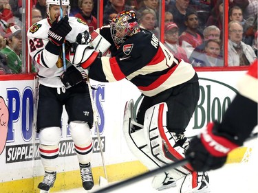 Craig Anderson of the Ottawa Senators hits (and gets a penalty) Kris Versteeg of the Chicago Blackhawks during second period NHL action.