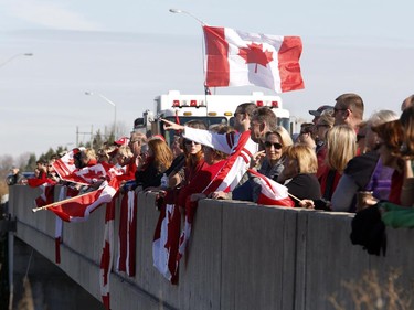 Crowds wait on an overpass at the Veterans Memorial Highway for a procession transporting the body of Cpl. Nathan Cirillo to pass by in Ottawa on Friday, October 24, 2014.