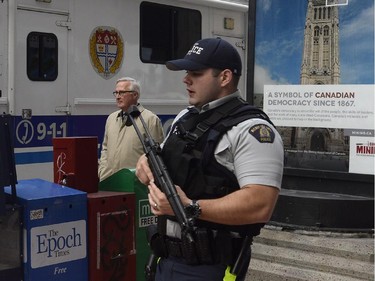 CSIS (secret service) head Richard Fadden walks past an RCMP officer as police secure an area around Parliament Hill in Ottawa on Wednesday Oct.22, 2014. A gunman opened fire at the National War Memorial, wounding a soldier, then moved to nearby Parliament Hill and wounded a security guard before he was shot, reportedly by Parliament's sergeant-at-arms.